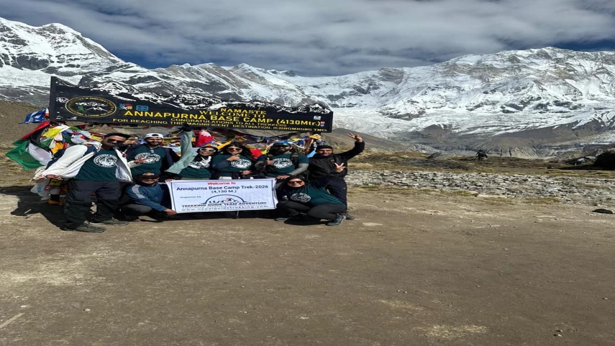 Group of trekkers at Annapurna Base Camp 4130m welcome sign Nepal
